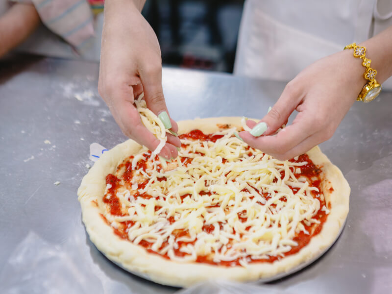 Sprinkling cheese on pizza